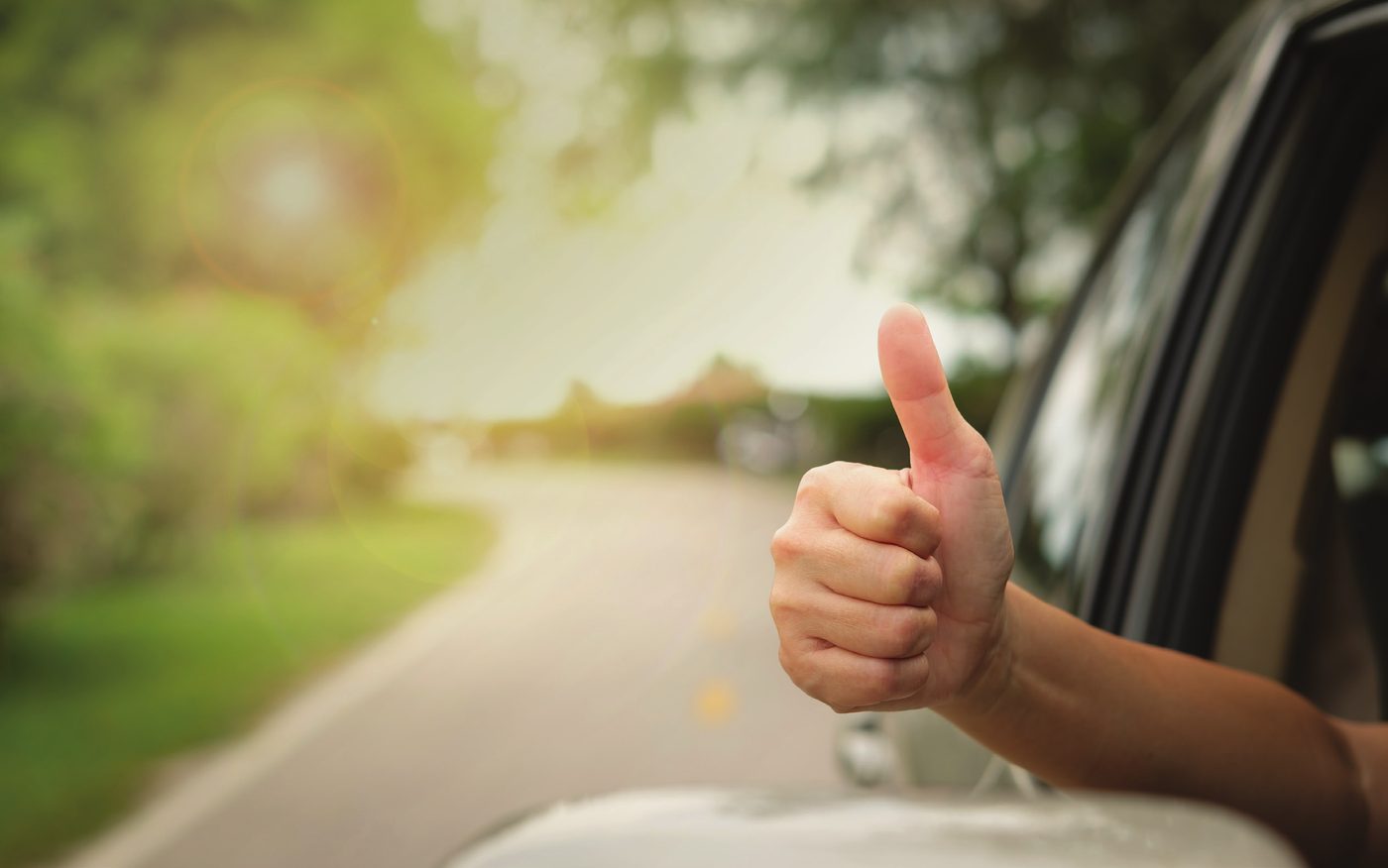 Driver giving a thumbs up from a car window